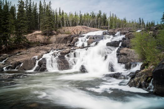 Stunning waterfall cascade surrounded by lush forest in Pinehouse, Saskatchewan, Canada.