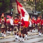 Festive marching band in Victoria, BC, celebrating with Canadian flags and colorful costumes.